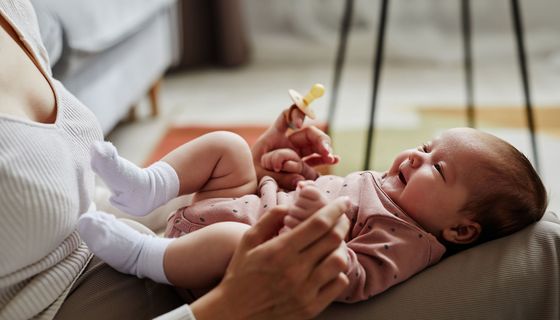 Baby, liegt bei der Mutter auf dem Schoß.