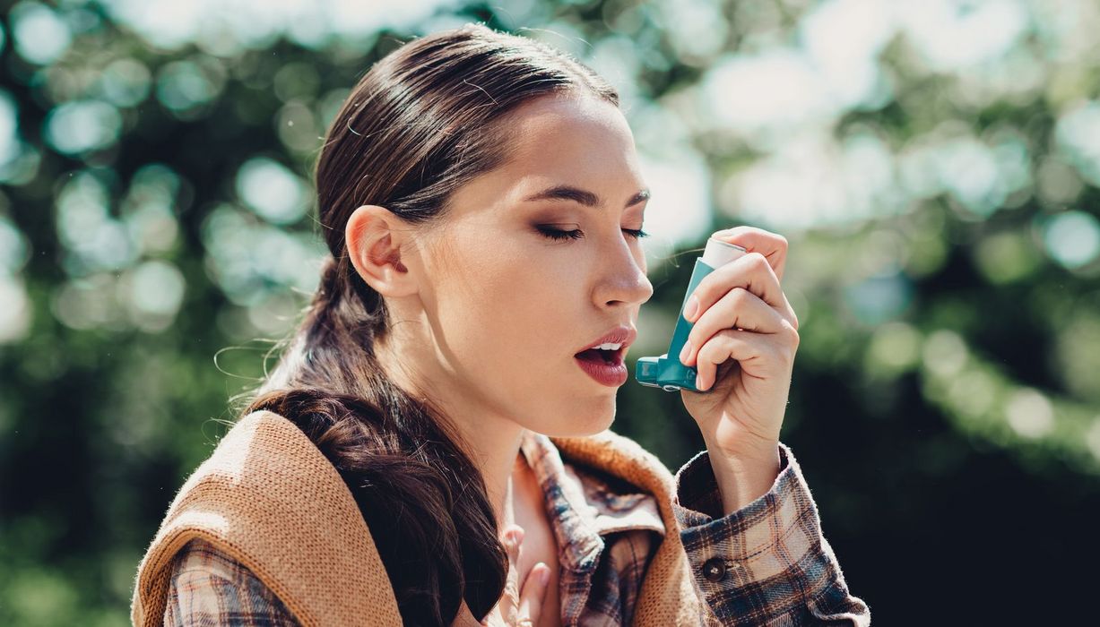 Frau inhaliert Asthmaspray.