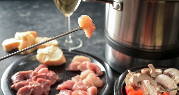 Fleischstück auf einer Fondue-Gabel.