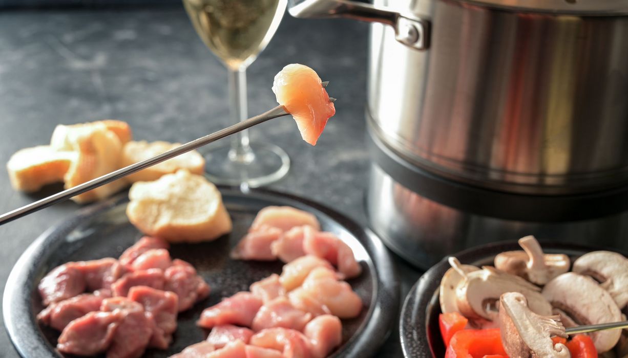 Fleischstück auf einer Fondue-Gabel.