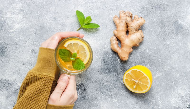 Frau mit einer Tasse Tee und Ingwer.