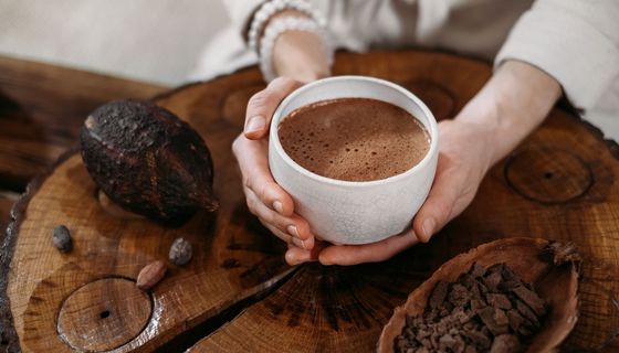 Frau, hält eine Tasse Kaffee in der Hand.