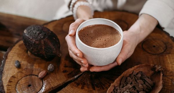 Frau, hält eine Tasse Kaffee in der Hand.