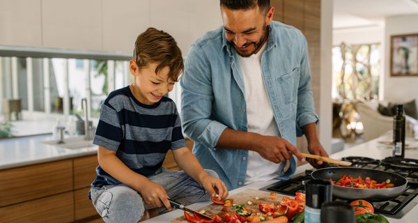 Mann, kocht mit seinem Sohn.