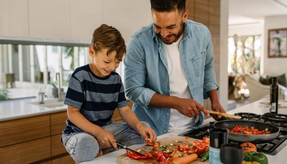 Mann, kocht mit seinem Sohn.