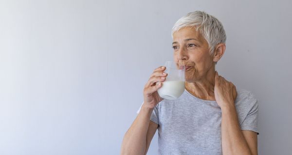 Ältere Frau, trinkt ein Glas Milch.