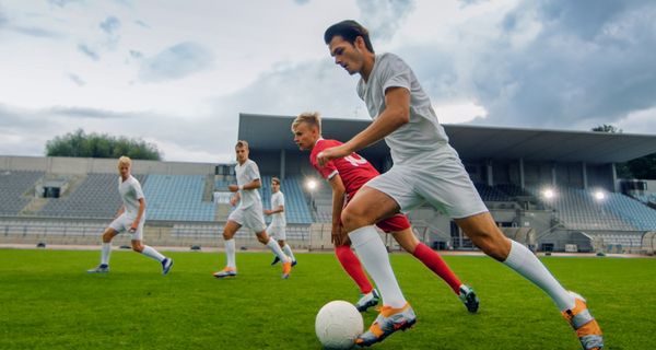 Junge Männer spielen Fußball.