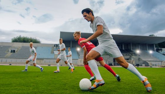 Junge Männer spielen Fußball.