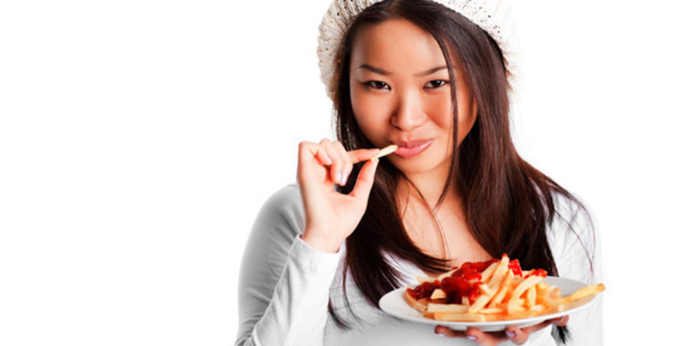 Junge Frau isst Pommes