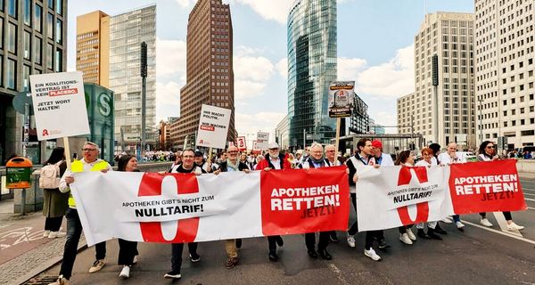 Demonstrationszug in Berlin: Sie tragen ein breites Banner mit der Aufschrift "Apotheken gibt's nicht zum Nulltarif!" und "Apotheken retten jetzt!"