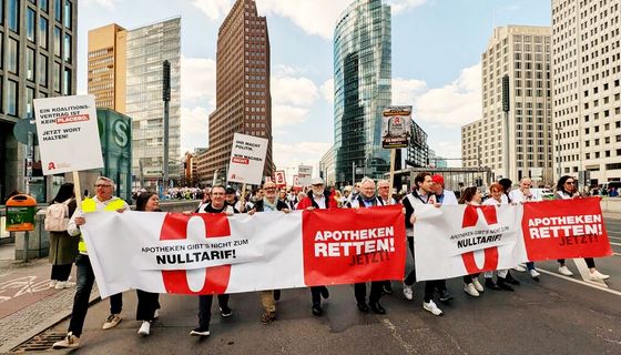 Demonstrationszug in Berlin: Sie tragen ein breites Banner mit der Aufschrift "Apotheken gibt's nicht zum Nulltarif!" und "Apotheken retten jetzt!"