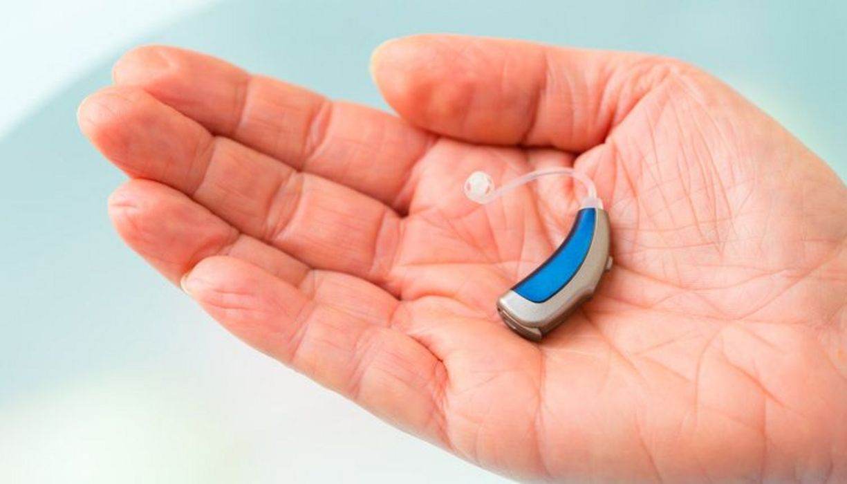 Kleines Hörgerät, blaumetallic, auf Handteller