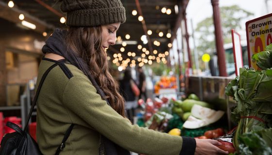 Junge Frau, kauft auf dem Markt ein.