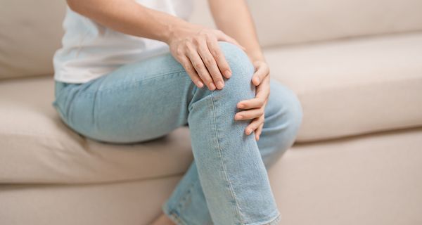 Frau, hält ihr Knie.