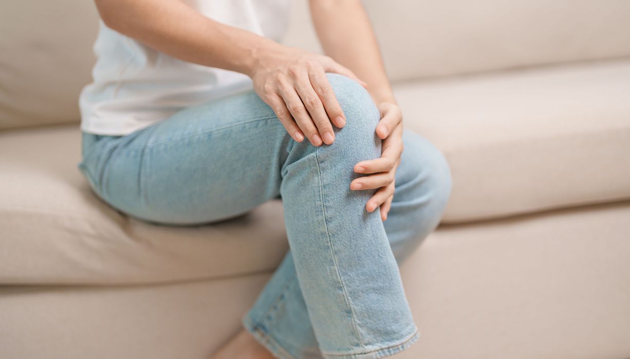 Frau, hält ihr Knie.