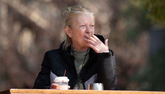 Ältere Frau raucht draußen.