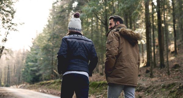 Mann geht mit seinem Sohn im Wald spazieren.