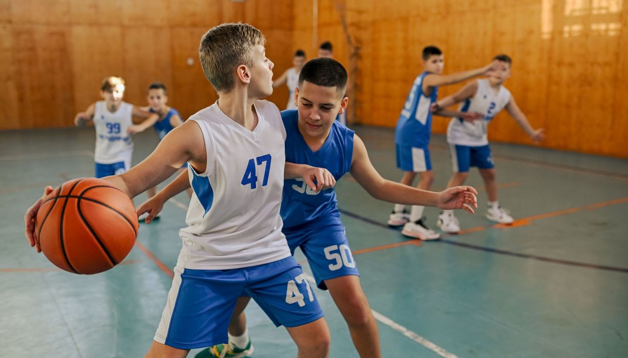 Jugendliche beim Basketballspielen.