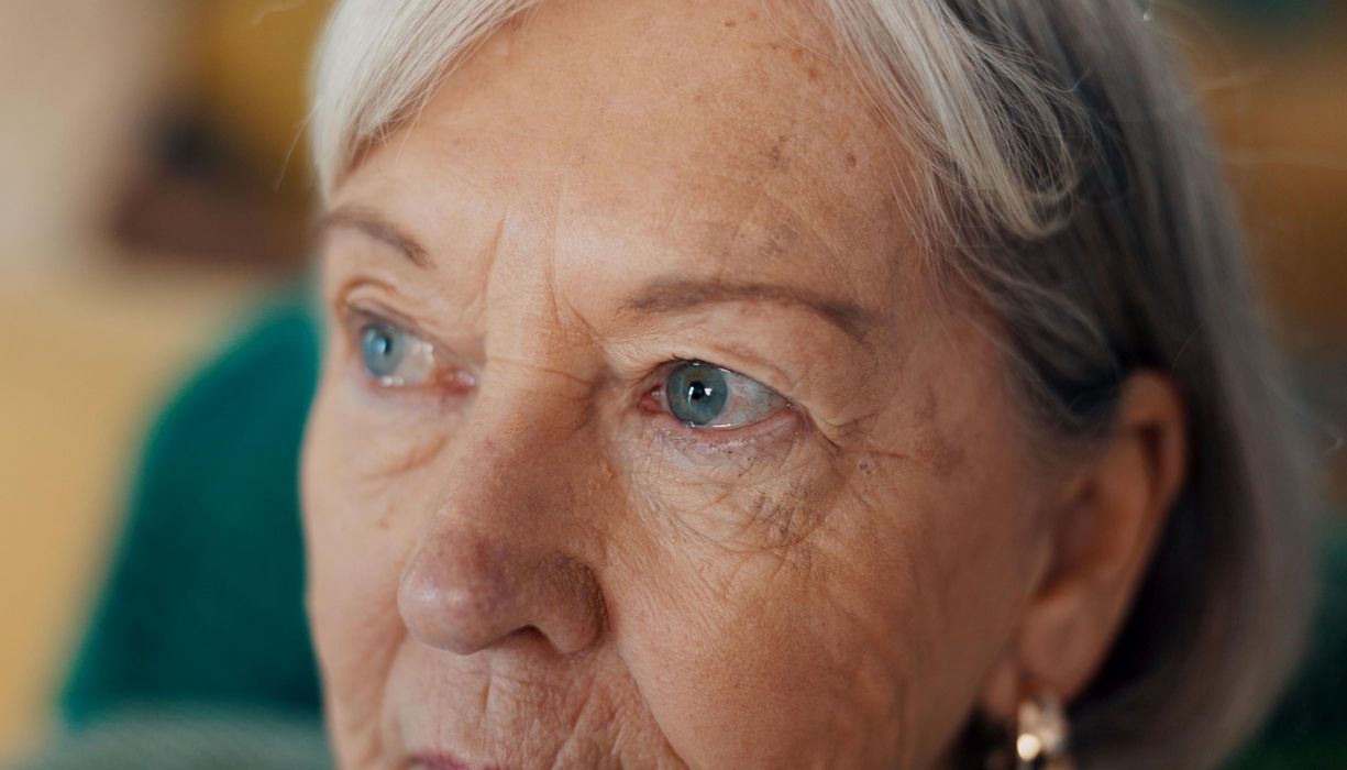 Nahaufnahme von der oberen Gesichtshälfte einer älteren Dame. Der Fokus liegt auf den Augen.