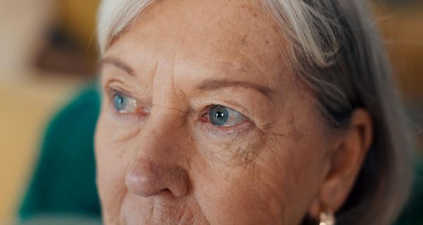 Nahaufnahme von der oberen Gesichtshälfte einer älteren Dame. Der Fokus liegt auf den Augen.