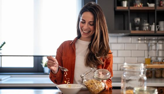 Frau bereitet ein Müsli zu.