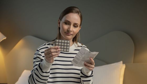 Junge Frau, liest eine Packungsbeilage