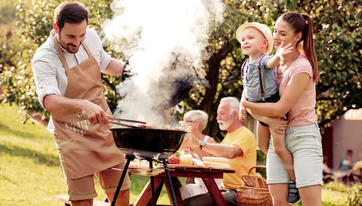 Familie grillt im Freien.