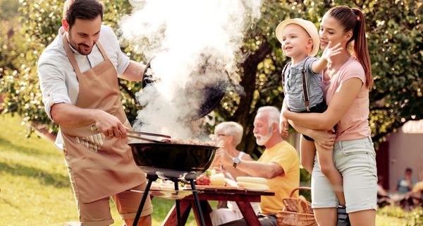 Familie grillt im Freien.