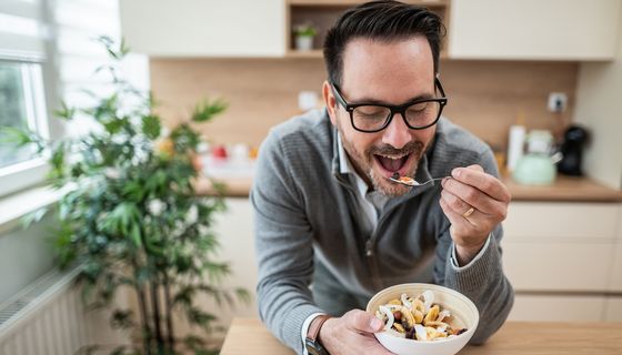 Mann, isst ein Müsli.