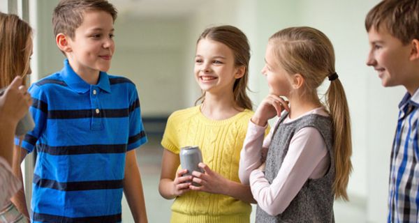 Gruppe von SchülerInnen, ca. 11-jährig, unterhalten sich, ein Mädchen hält eine Dose (Energydrink) in der Hand.