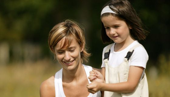 Kleines Mädchen mit Mutter auf der Wiese.
