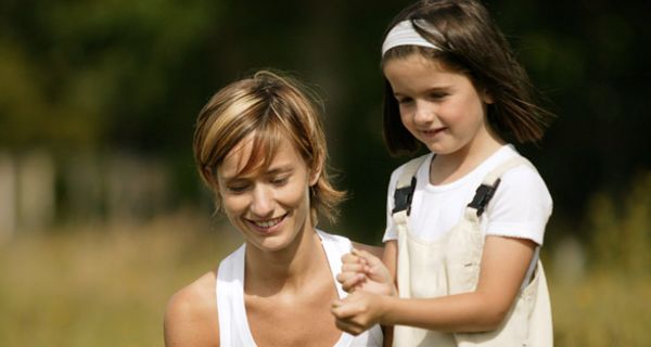 Kleines Mädchen mit Mutter auf der Wiese.