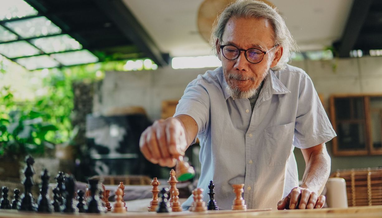 Älterer Mann, spielt Schach.