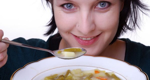 Frau löffelt Suppe