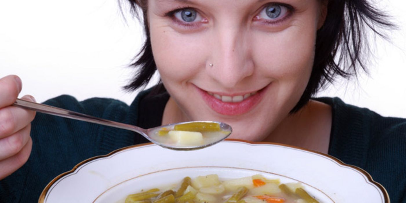 Frau löffelt Suppe