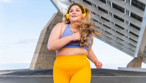 Übergewichtige junge Frau joggt.