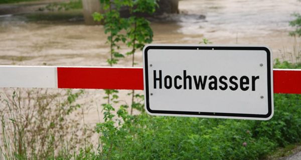 Hochwasser führender Fluss mit Hochwasser-Warnschild