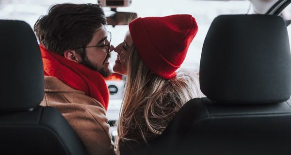 Mann und Frau, sitzen im Auto und küssen sich.