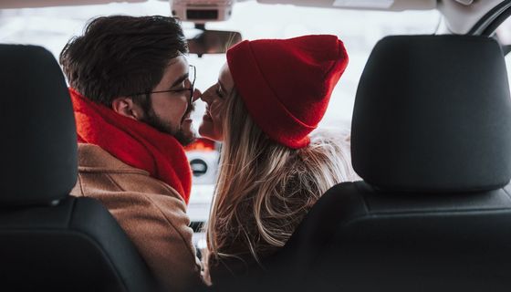 Mann und Frau, sitzen im Auto und küssen sich.