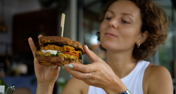 Frau, isst einen vegetarischen Burger.