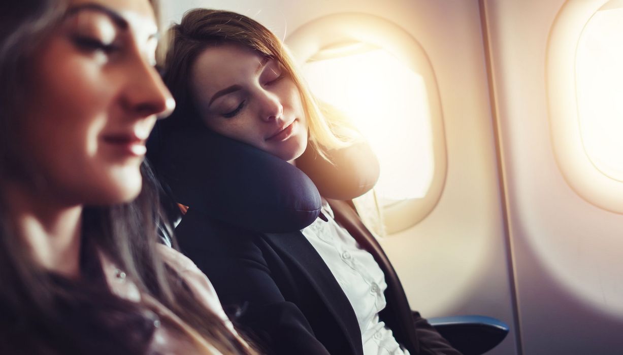 Zwei junge Frauen, schlafen im Flugzeug.