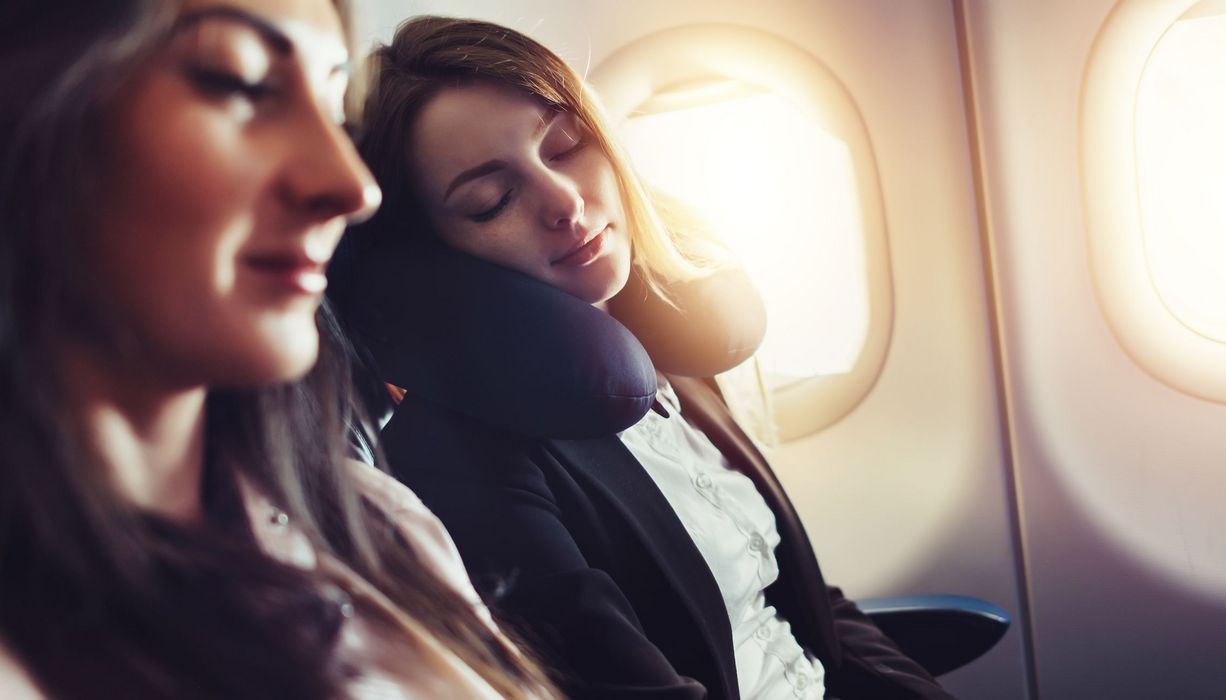 Zwei junge Frauen, schlafen im Flugzeug.