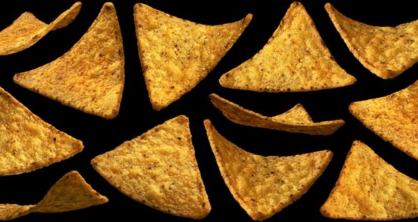 Tortilla Chips auf schwarzem Hintergrund.