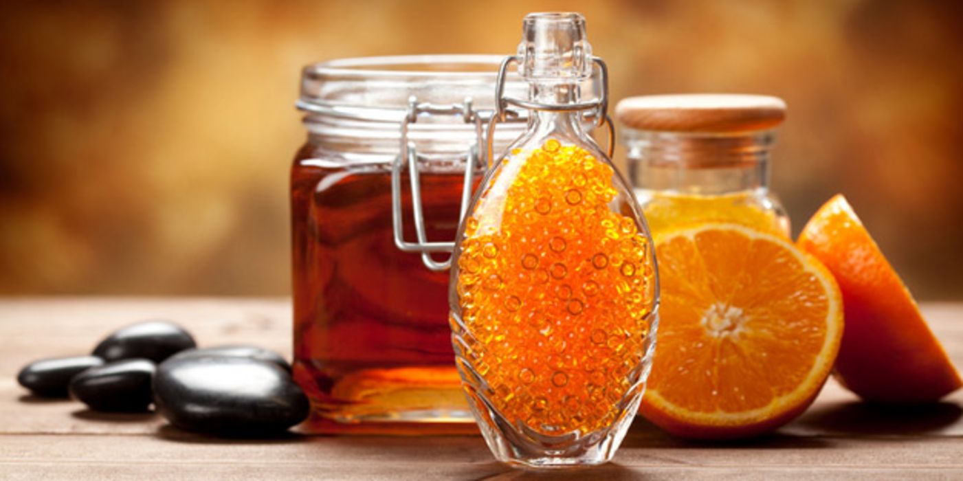 Honiggläser und aufgeschnittene Zitrusfrüchte