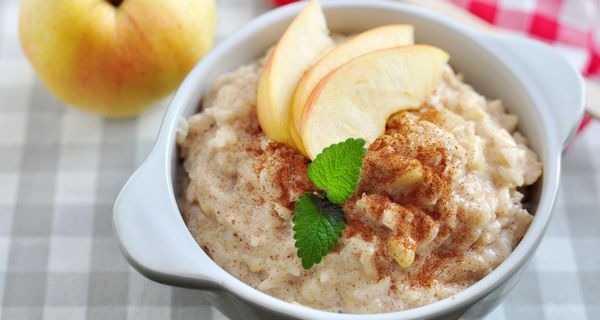 Schüssel mit Haferbrei und einem Apfel-Schnitz.