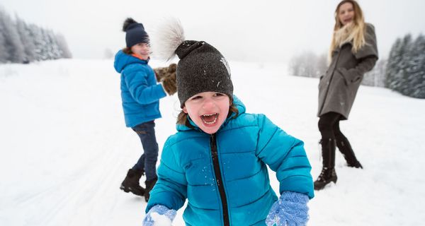 Kind, spielt draußen im Schnee.