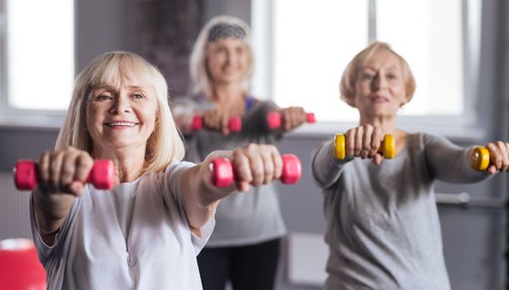 Drei Frauen trainieren mit Hanteln.