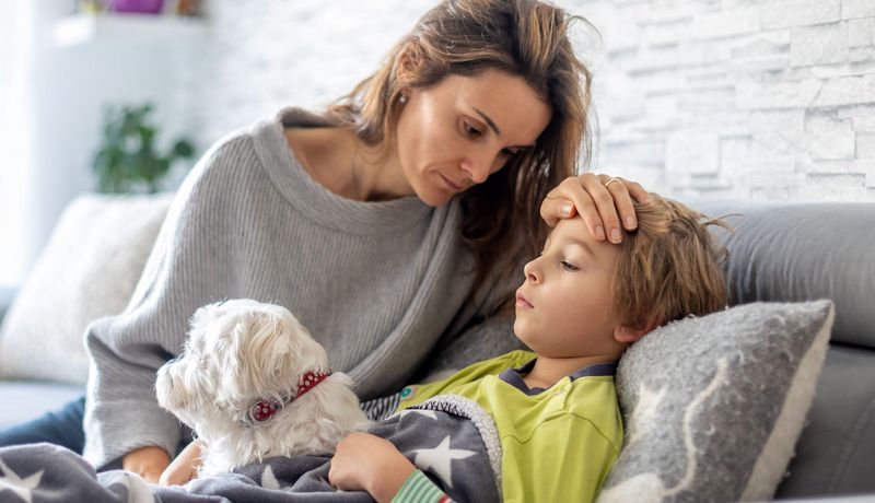 Mutter kümmert sich um kranken Sohn.