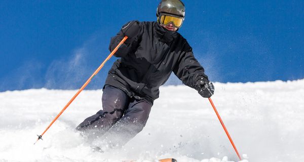 Ein Mann mit Helm fährt Ski.