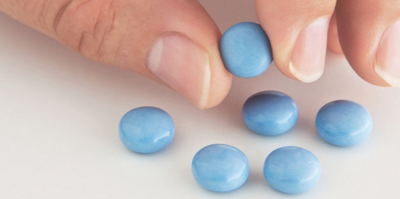Hand mit blauen Tabletten